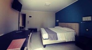 A modern bedroom with a bed, bedside table, and a desk. - Guesthouse San Domenico (Augusta)