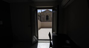 A room with a door leading to a courtyard. - Guesthouse San Domenico (Augusta)