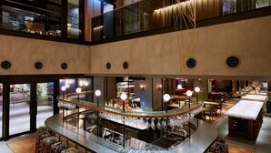 A multi-level bar area with a central bar, seating, and a view of the street below.