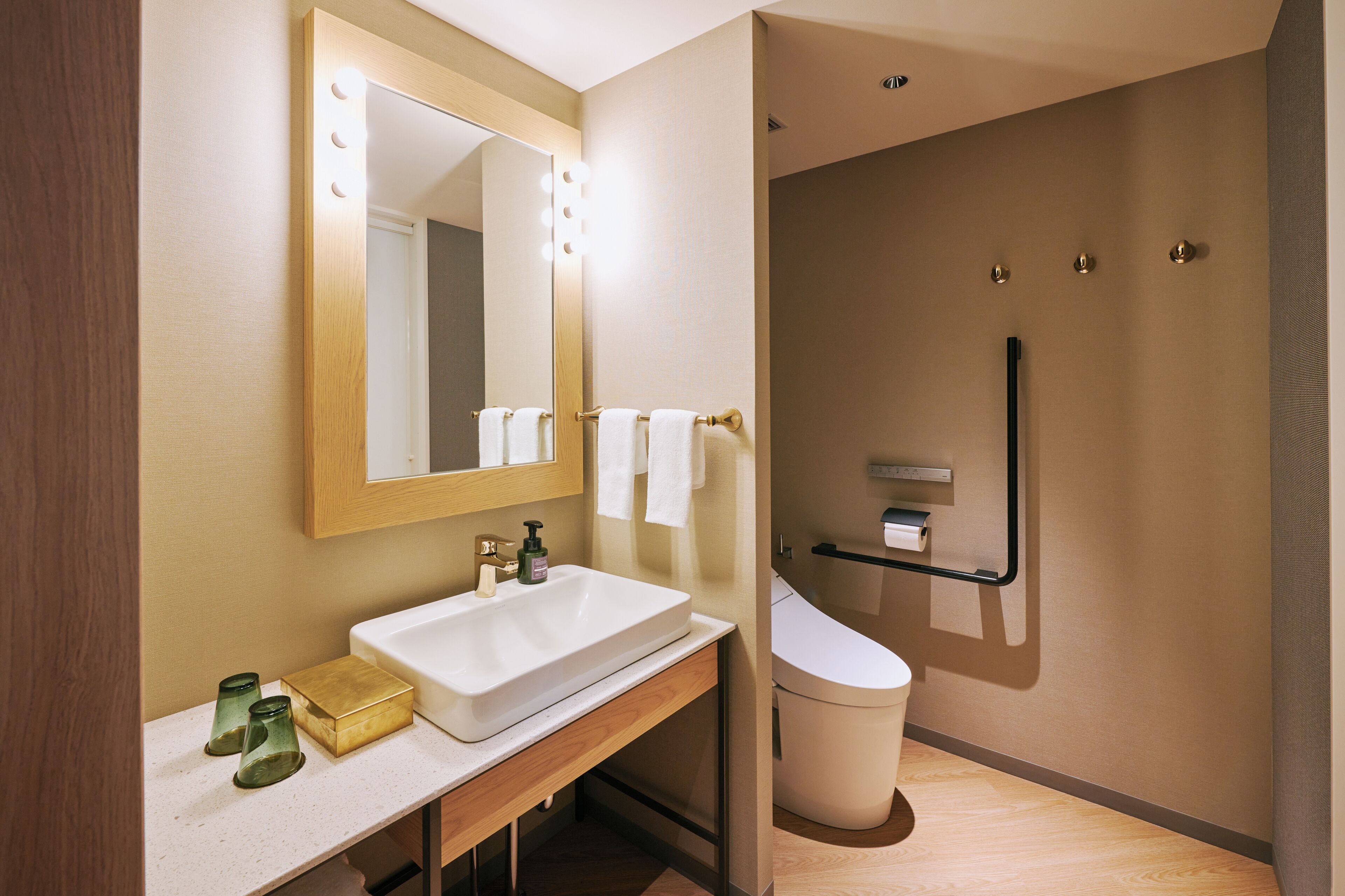 A modern bathroom with a large mirror, white sink, and a walk-in shower.