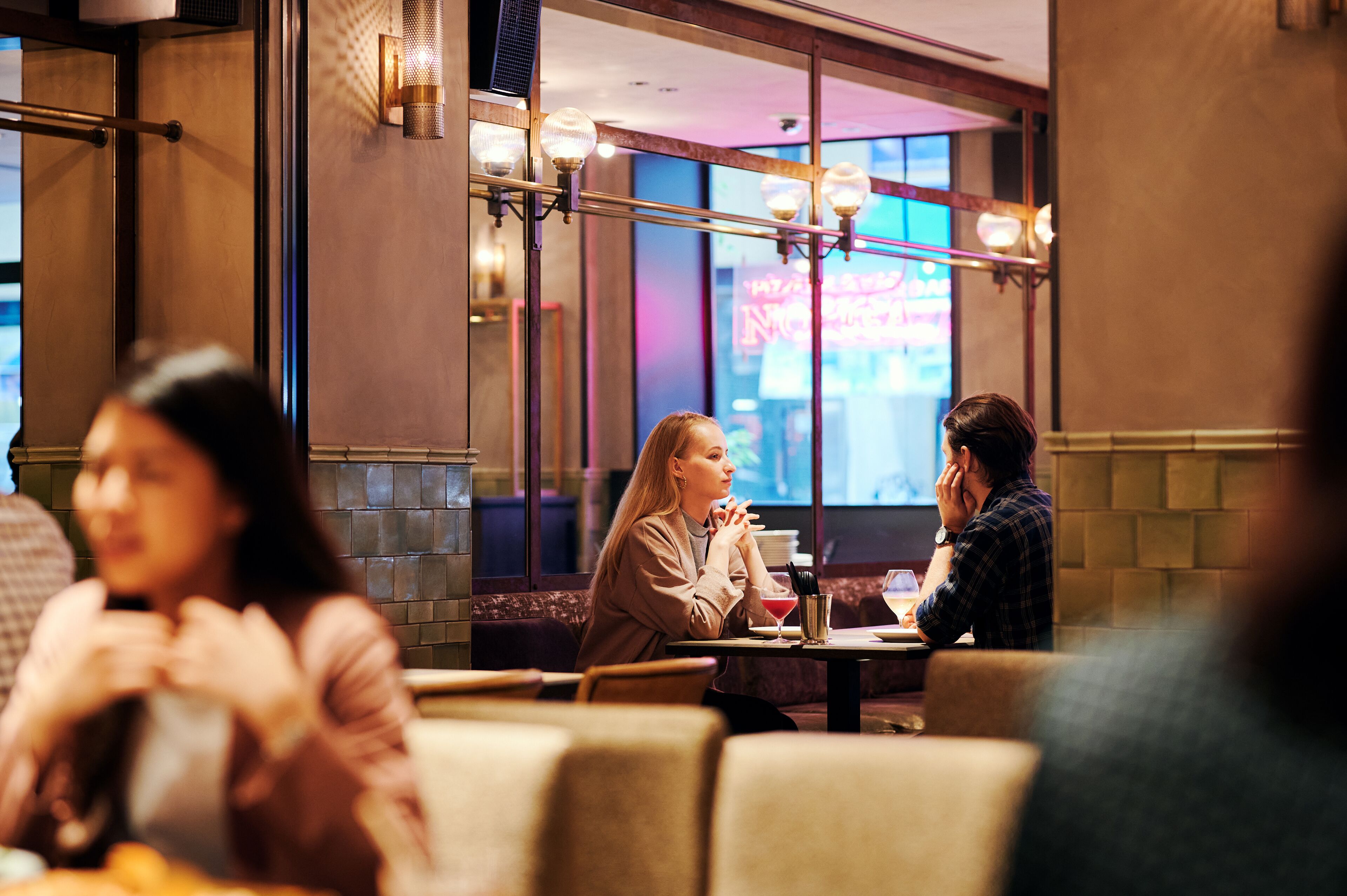 Ein Restaurantinneres mit Sitzecken, Tischen und einem großen Fenster mit Ausblick.