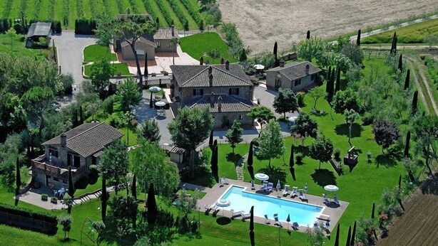 Una extensa propiedad con piscina, varias construcciones y jardines bien cuidados.
