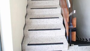 A staircase with a wooden handrail and a beige wall with a framed picture. - Franken Motel (Fuerth)