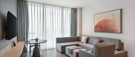 Una sala de estar moderna con un sofá gris, una mesa de centro y un televisor de pantalla plana.