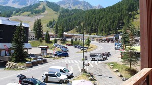 Une ville de montagne dotée d’un parking, d’un magasin Vans et offrant une vue sur les montagnes environnantes.