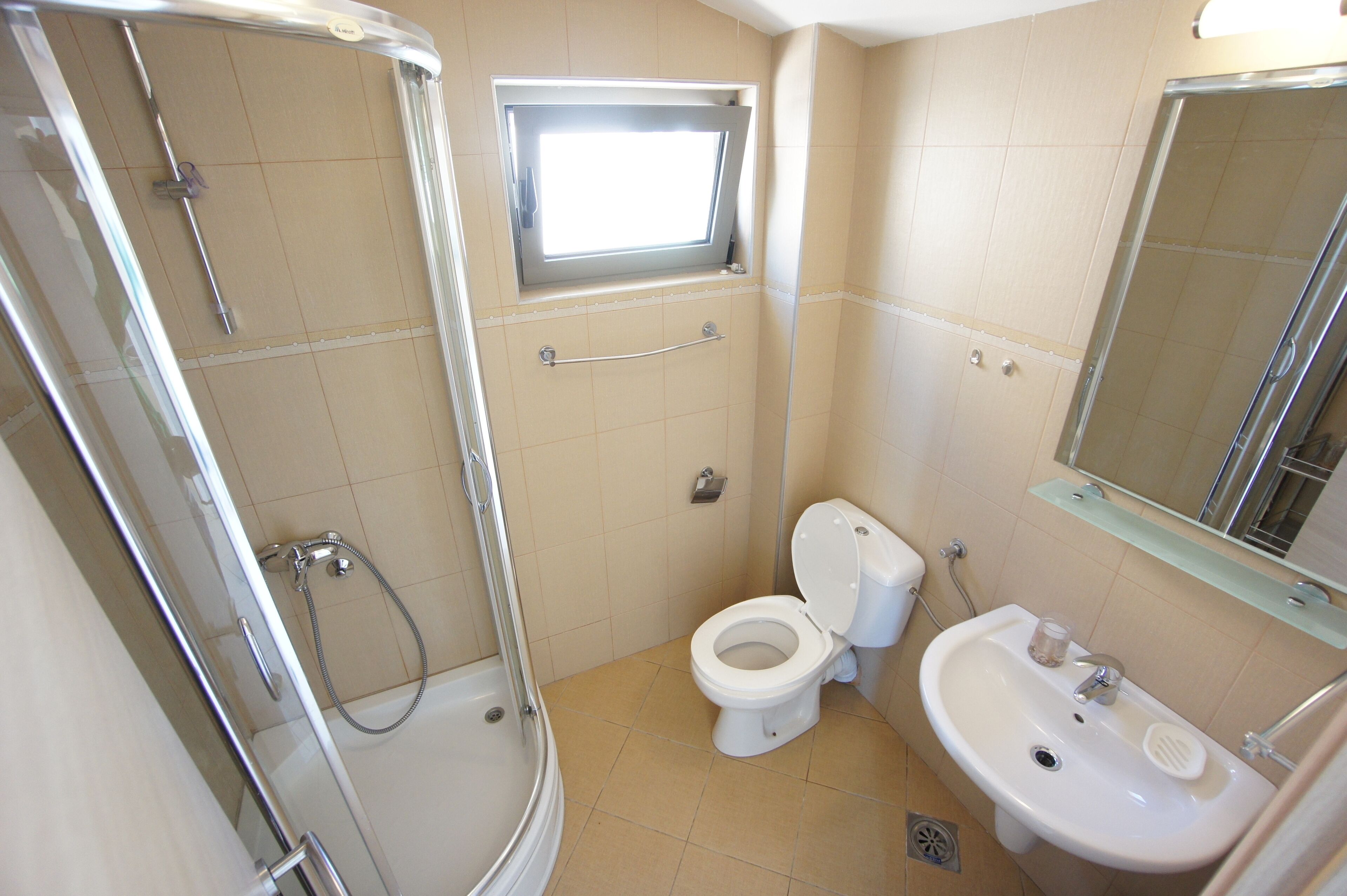 Ein Badezimmer mit Dusche, Toilette und Waschbecken.