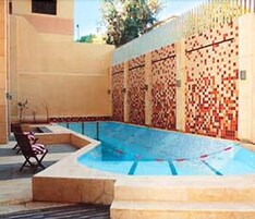 Una piscina al aire libre de temporada, sombrillas