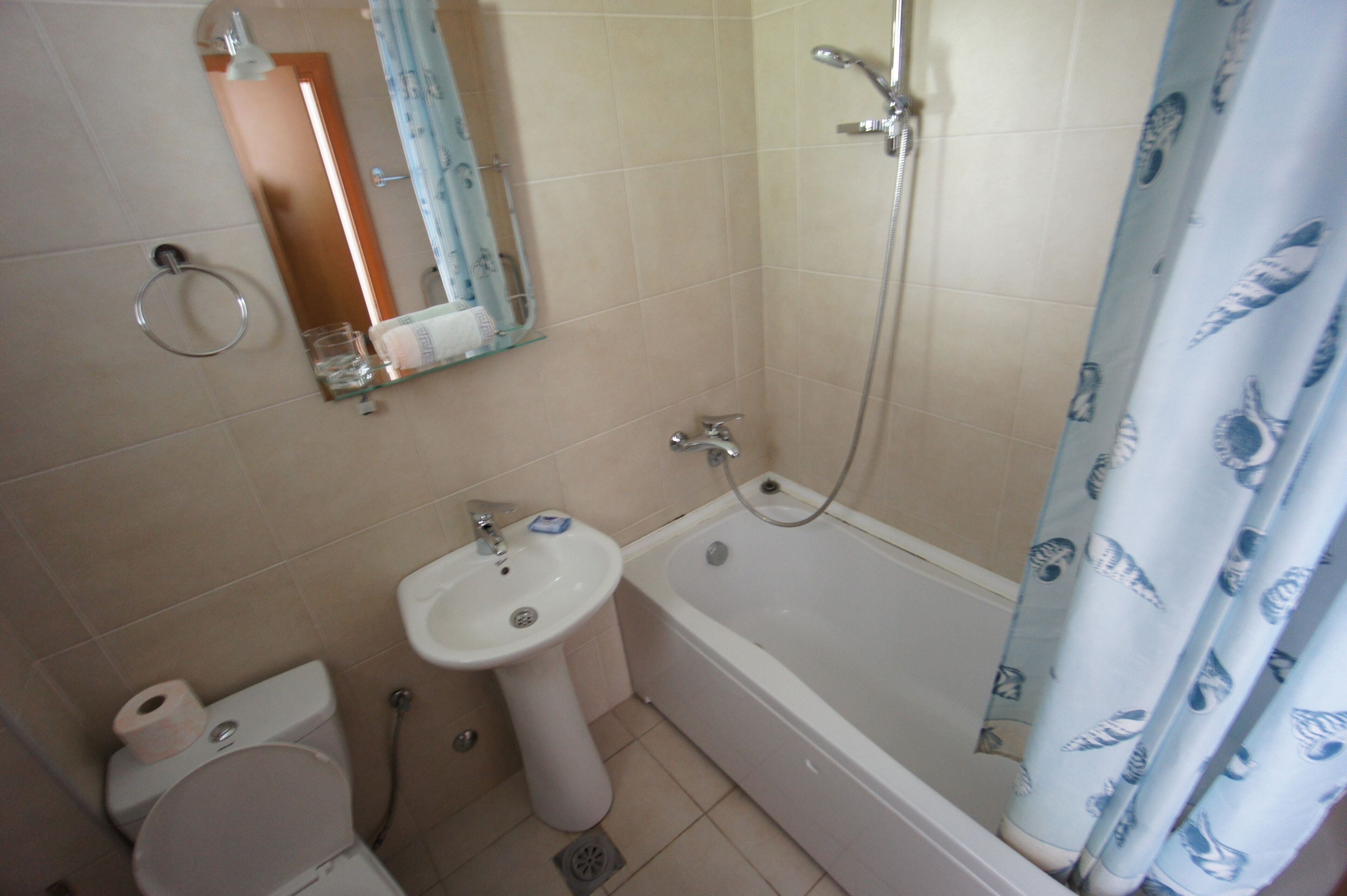 A bathroom with a toilet, sink, and bathtub.