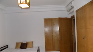 Ein Schlafzimmer mit einem Bett, einem Holzschrank und einer Deckenleuchte.