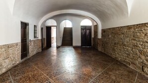 Ein Korridor mit gewölbter Decke, Steinwänden und Fliesenboden.