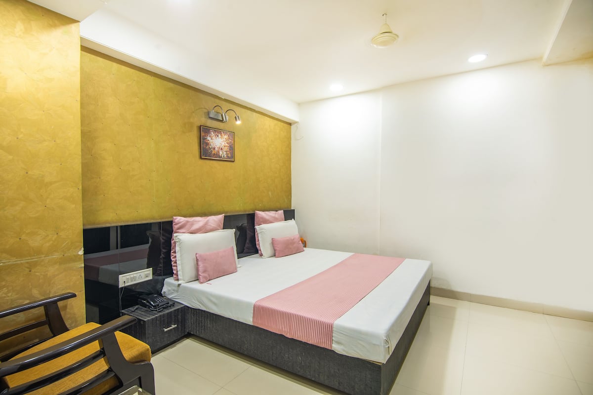 A bedroom with a bed, bedside table, and a chair.