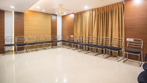 Ein Konferenzraum mit langem Tisch, Stühlen, Holzwänden und Deckenventilatoren.