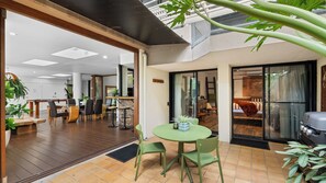A modern interior with a dining area, a kitchen, and a living space. - Luxury Pool Side Apartment in Beachfront Resort (Cairns North)