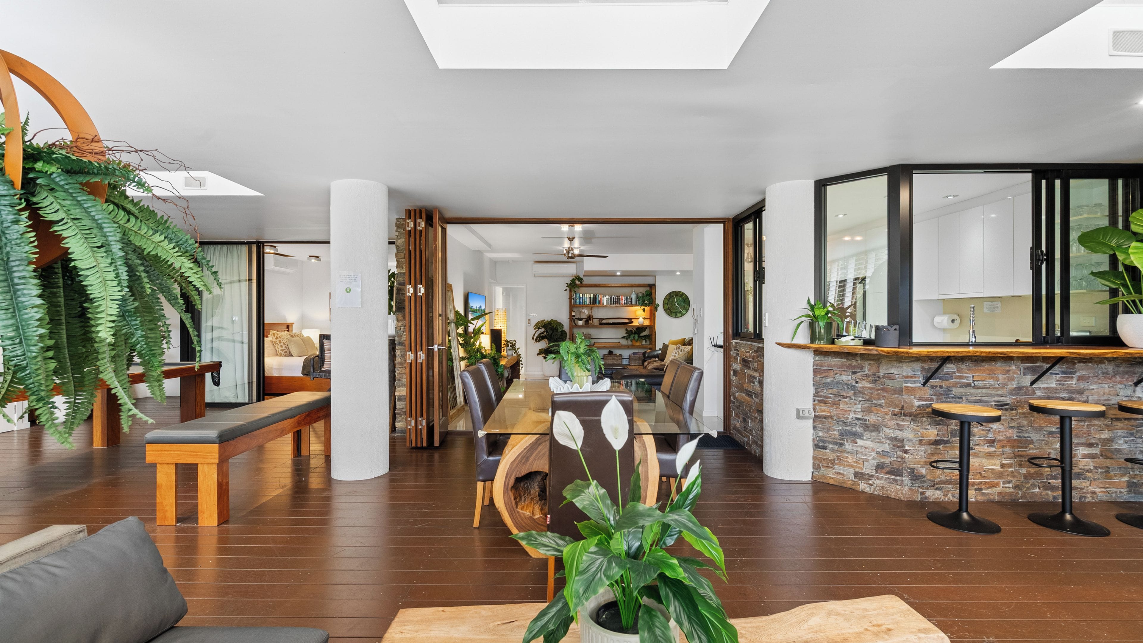 A spacious living area with a dining table, seating, and a kitchen in the background.