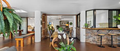 A spacious living area with a dining table, seating, and a kitchen in the background.