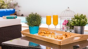 A breakfast tray with croissants, two glasses of orange juice, and a white birdcage with flowers. - Aquavilla Private Pool (Costa Teguise)