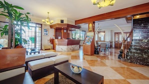 A spacious lobby with a reception desk, seating area, and a staircase leading to a lower level. - Hotel Ses Puntetes (Santanyi)