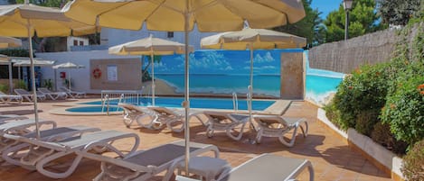 Een seizoensgebonden buitenzwembad en parasols bij het zwembad