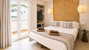 A bedroom with a bed, a wardrobe, a bedside table, and a view of the outside. - Hotel Ses Puntetes (Santanyi)