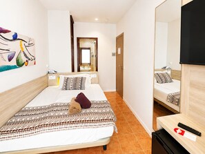 A hotel room with a bed, a bedside table with a phone, a mirror, and a TV. - Hotel Ses Puntetes (Santanyi)