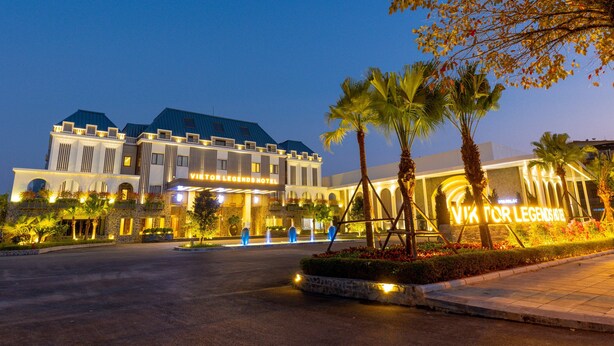 A hotel with a modern architectural design, featuring a prominent entrance with illuminated signage. - Viktor Legends Hotel (Mong Cai)