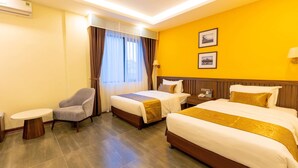 A hotel room with two beds, a chair, a small table, and a window with curtains. - Viktor Legends Hotel (Mong Cai)