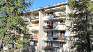 A multi-story building with balconies, surrounded by trees. - Studio for 4 near slopes in Vars (Vars)