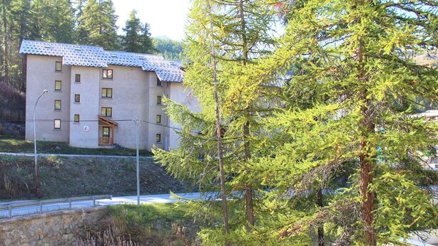 A building with a tiled roof and multiple windows, surrounded by trees and a stone wall. - Studio for 4 near slopes in Vars (Vars)