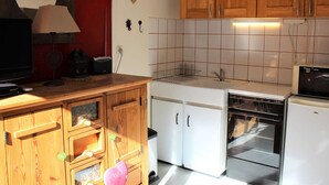 A compact kitchen with wooden cabinets, a white sink, and a dishwasher. - Studio for 4 near slopes in Vars (Vars)