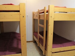 A bunk bed room with two wooden bunk beds, each with a purple mattress. - Cozy Studio with Balcony, Sleeps 6, Close to Ski Lifts and Shops, Vars Les Claux (Vars)