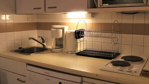 A kitchen with a Bosch dishwasher, a coffee maker, a microwave, and a stove.
