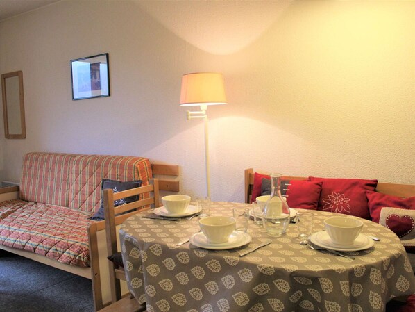 Una stanza accogliente con un letto, un tavolo apparecchiato per il tè e una lampada.