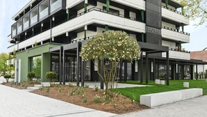A modern building with a green facade, multiple balconies, and a sign reading "The Royal". - Appartement Hotel Royal (Bad Fuessing)
