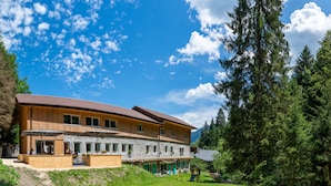 A two-story wooden building with a stone facade, large windows, and a balcony. - Chambres d'Hôtes Sanskriti (Scionzier)