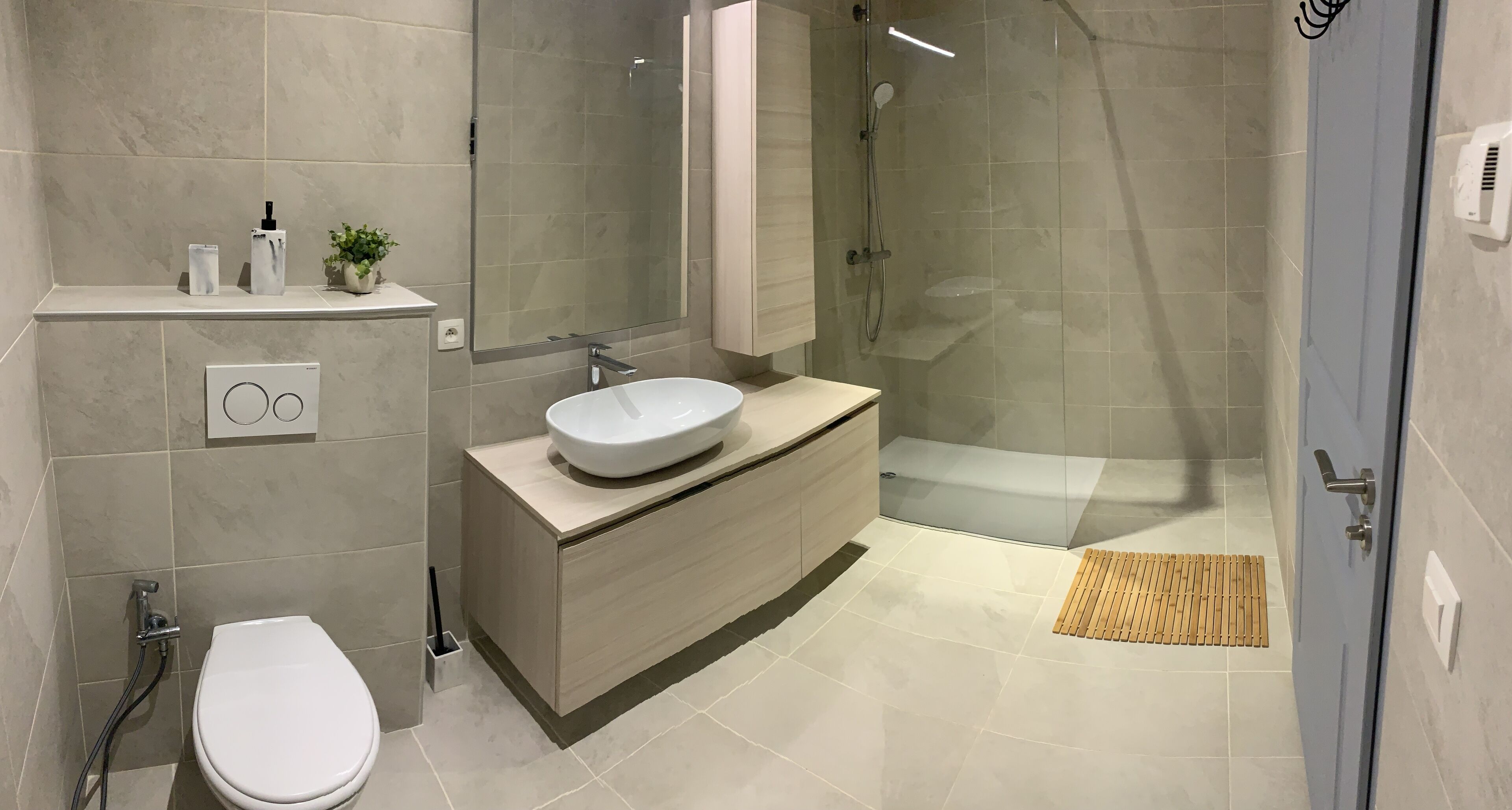 A modern bathroom with a toilet, sink, and shower.