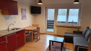 Un espacio habitable compacto con cocina, comedor y zona de estar.