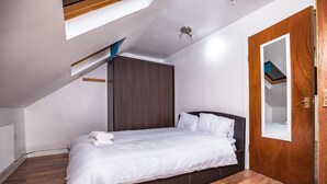 A bedroom with a bed, wooden flooring, a wardrobe, and a door with a mirror. - 6 Bedrooms House NOT FAR from Central London, ECEL LONDON, CANARY WHARF O2 (Barking)