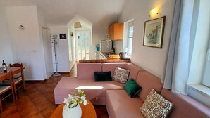 Ein gemütliches Wohnzimmer mit Essbereich, einer Küchenzeile und einem Badezimmer.