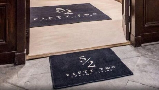Een houten trap met een leuning, een bankje en een deur onderaan.