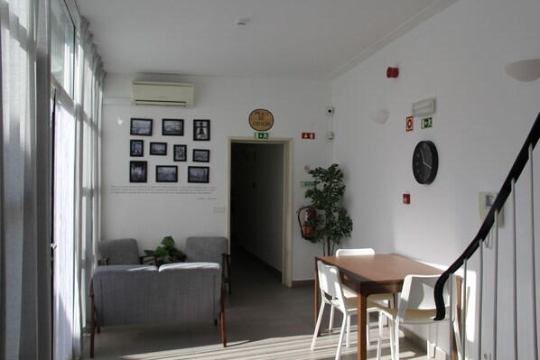 Una habitación con una mesa de comedor, sillas, un sofá y una escalera.
