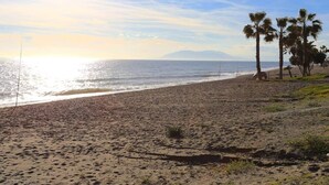 Platja de sorra, palmeres i cel serè.