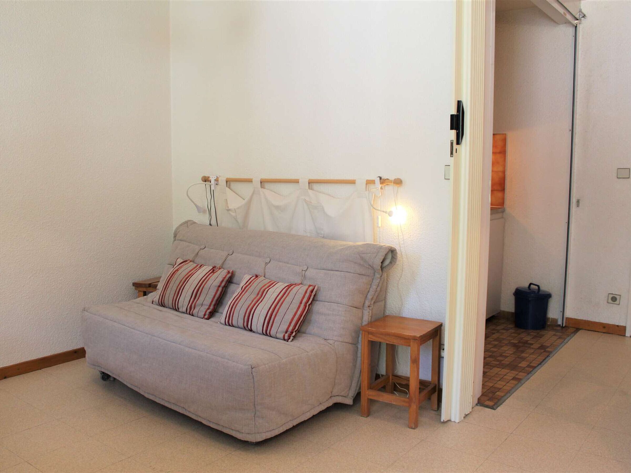 Une petite pièce agréable, avec un canapé, une table d’appoint en bois et un radiateur.