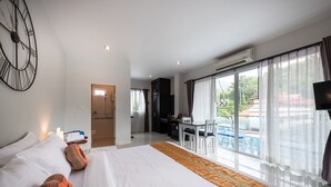 Hotellihuone, jossa on suuri sänky, työpöytä ja näkymä ulos.
