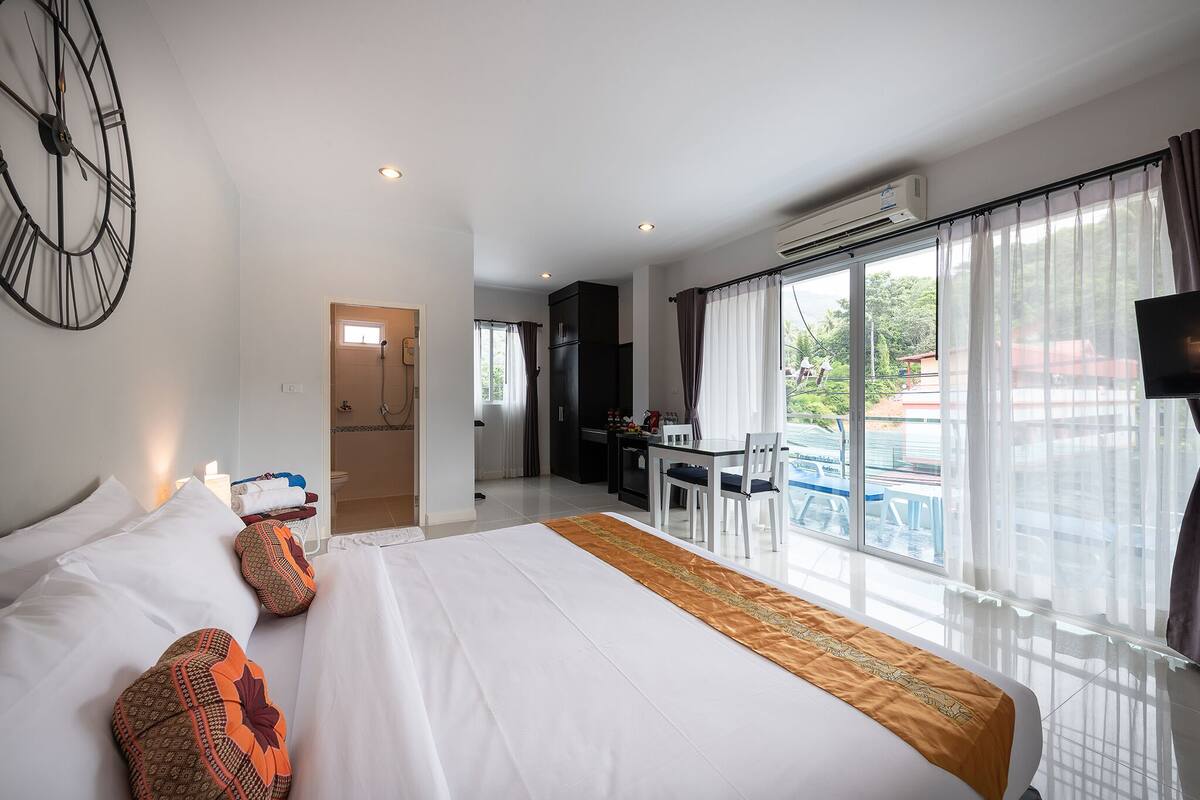 Une chambre d’hôtel avec un grand lit, un bureau et une vue sur l’extérieur.