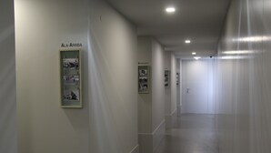 A corridor with framed pictures on the walls and a door at the end. - StayInn City - Póvoa de Varzim (Povoa De Varzim)
