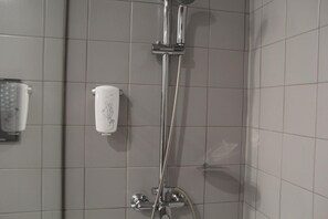Une douche équipée d’un pommeau de douche à main et d’un robinet fixé au mur.