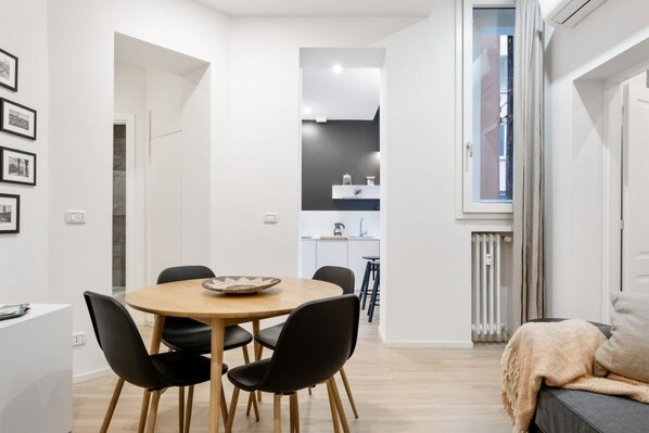 A modern living space with a dining area, kitchen, and a cozy seating area.