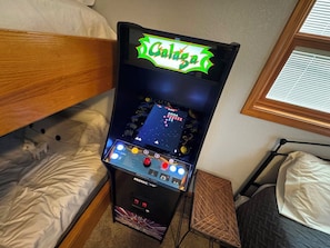A gaming console in a hotel room with a bed, a small table, and a window. - Casa Del Sol - Three Bedroom House, Sleeps 10 (Rocky Mount)