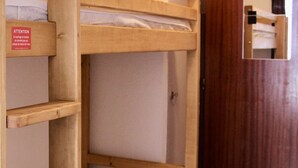 Uma cama beliche com estrutura de madeira e uma etiqueta na lateral.