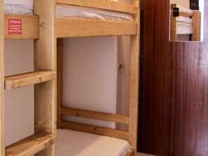 Letto a castello con struttura in legno ed etichetta laterale.